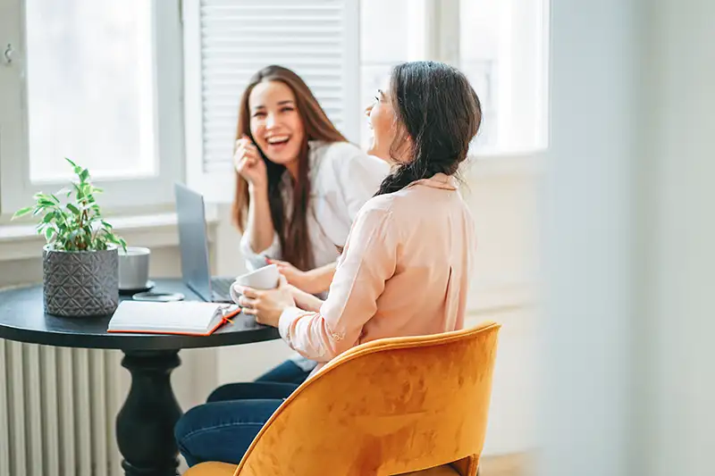 Two women having a friendly consultation during the initial surrogate screening process.